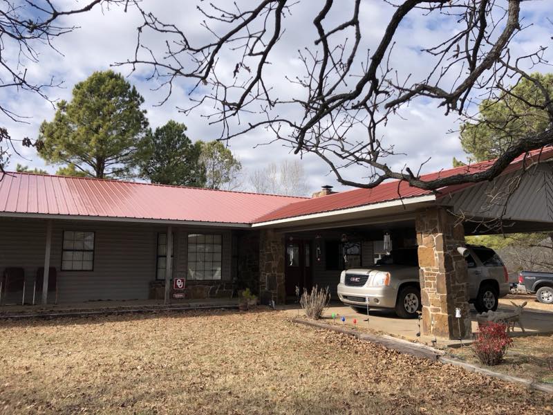 Home with a red metal roof and attached carport